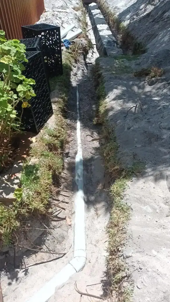 A PVC waste line laid in a residential trench.